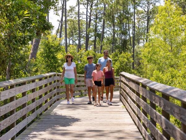 Family walking along the boardwalk trails within Gulf State Park