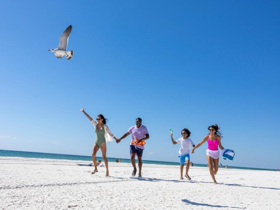 Family running on the beach at Gulf Place, public beach in Gulf Shores